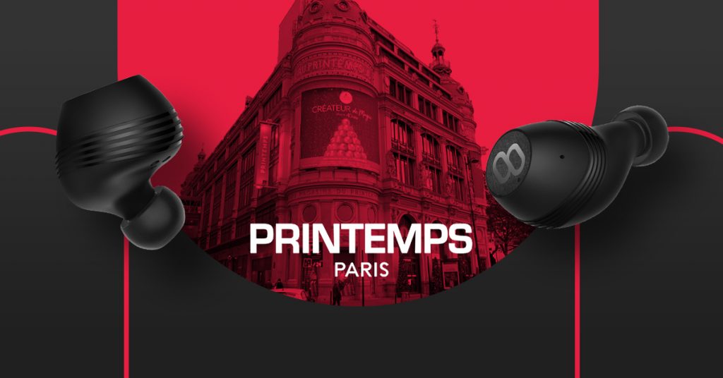 Black translation earbuds with Paris Printemps backdrop, ideal for real-time language travel use