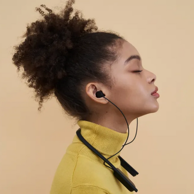 Woman wearing wireless translator earbuds with neckband for real-time language translation