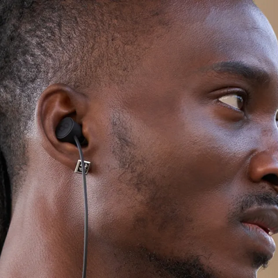 Man wearing black wireless earbuds for real-time translation during travel or business conversations